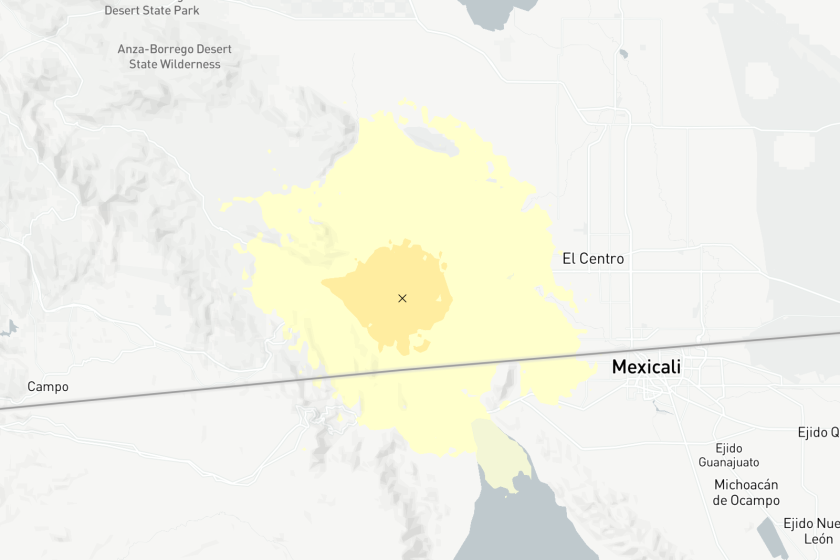 A man shows the location of an earthquake at the U.S.-Mexico border.